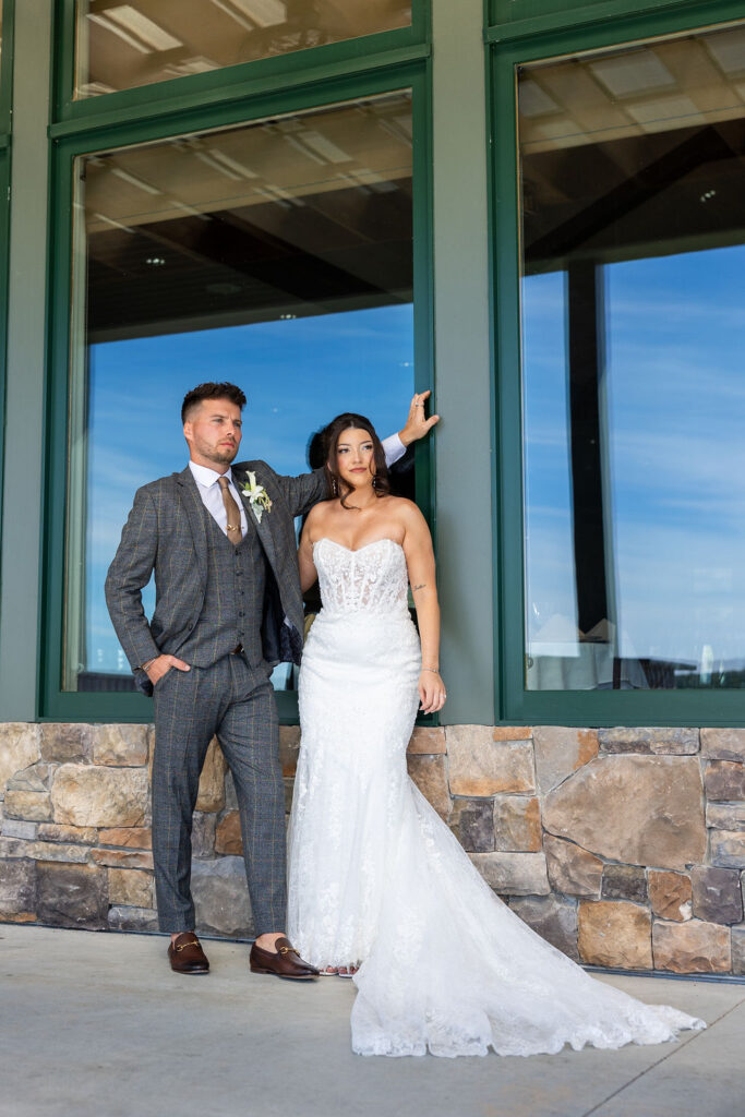 Life In Focus Maine Photographers, bride and groom pose in front of large window