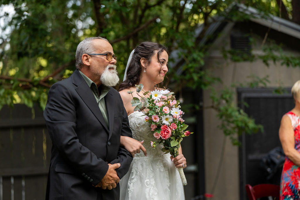 Life In Focus Maine Wedding Photographers, bride is walked down the aisle with trees in background