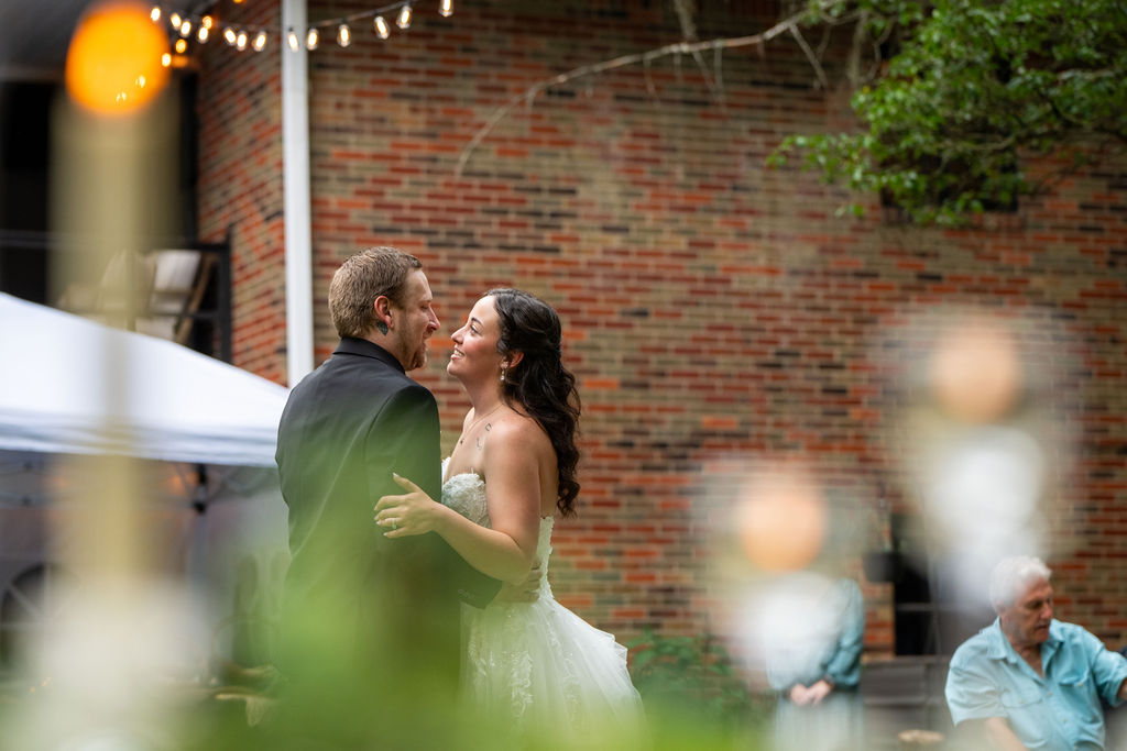 Life In Focus Maine Wedding Photographers, candid photo of newlyweds sharing an embrace and dance on a green